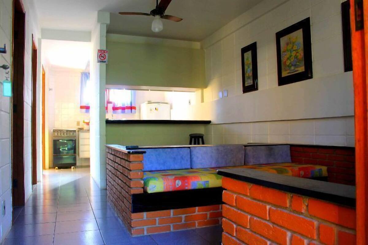 A kitchen with a built-in seating area, a ceiling fan, and a refrigerator.