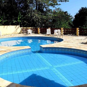 Una piscina al aire libre, tumbonas