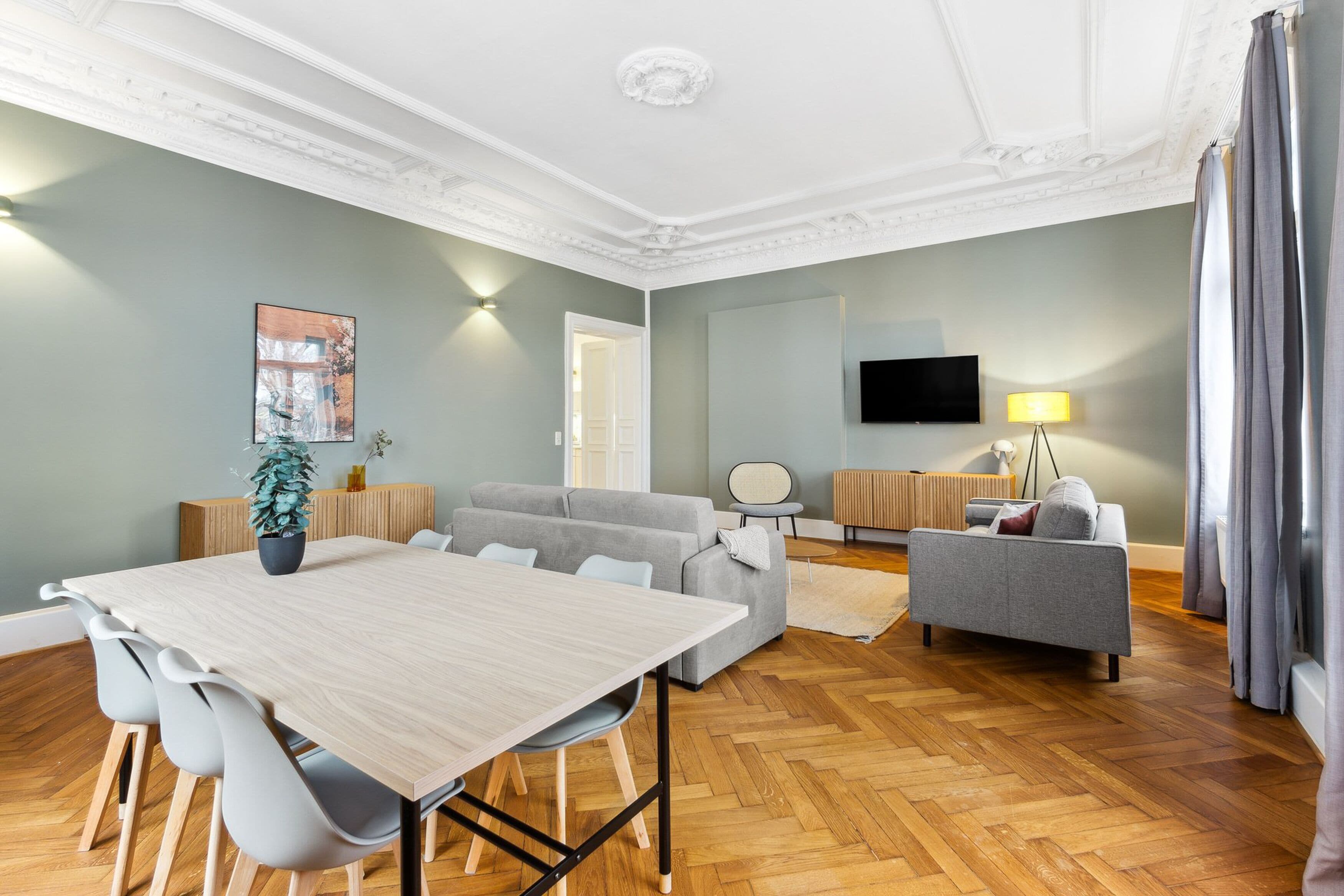 En moderne stue med spisebord, sofaer og et fjernsyn.