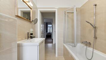 A modern bathroom with a bathtub, a sink, and a mirror.