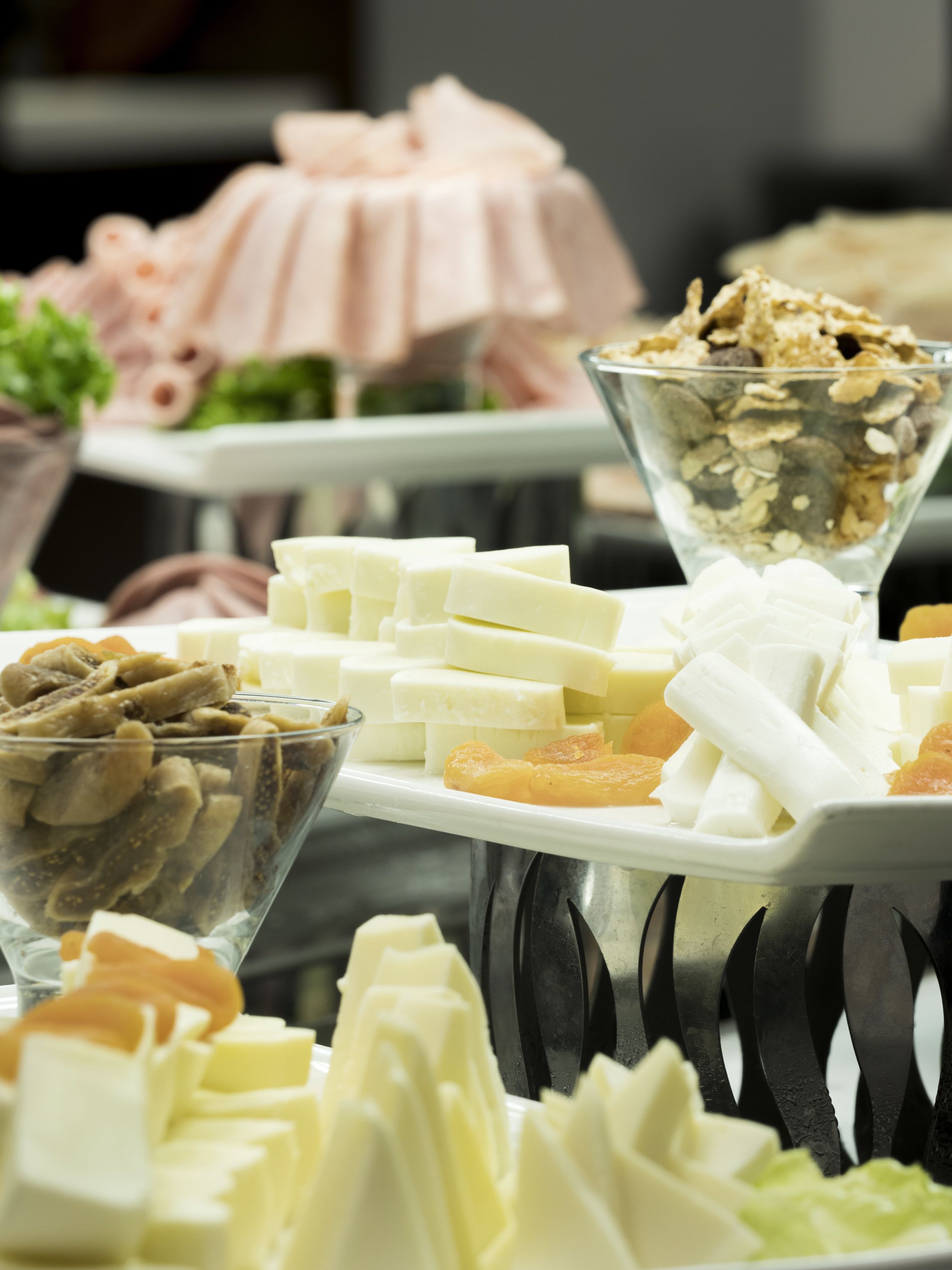 A buffet table with various food items including cheese, fruits, and nuts.