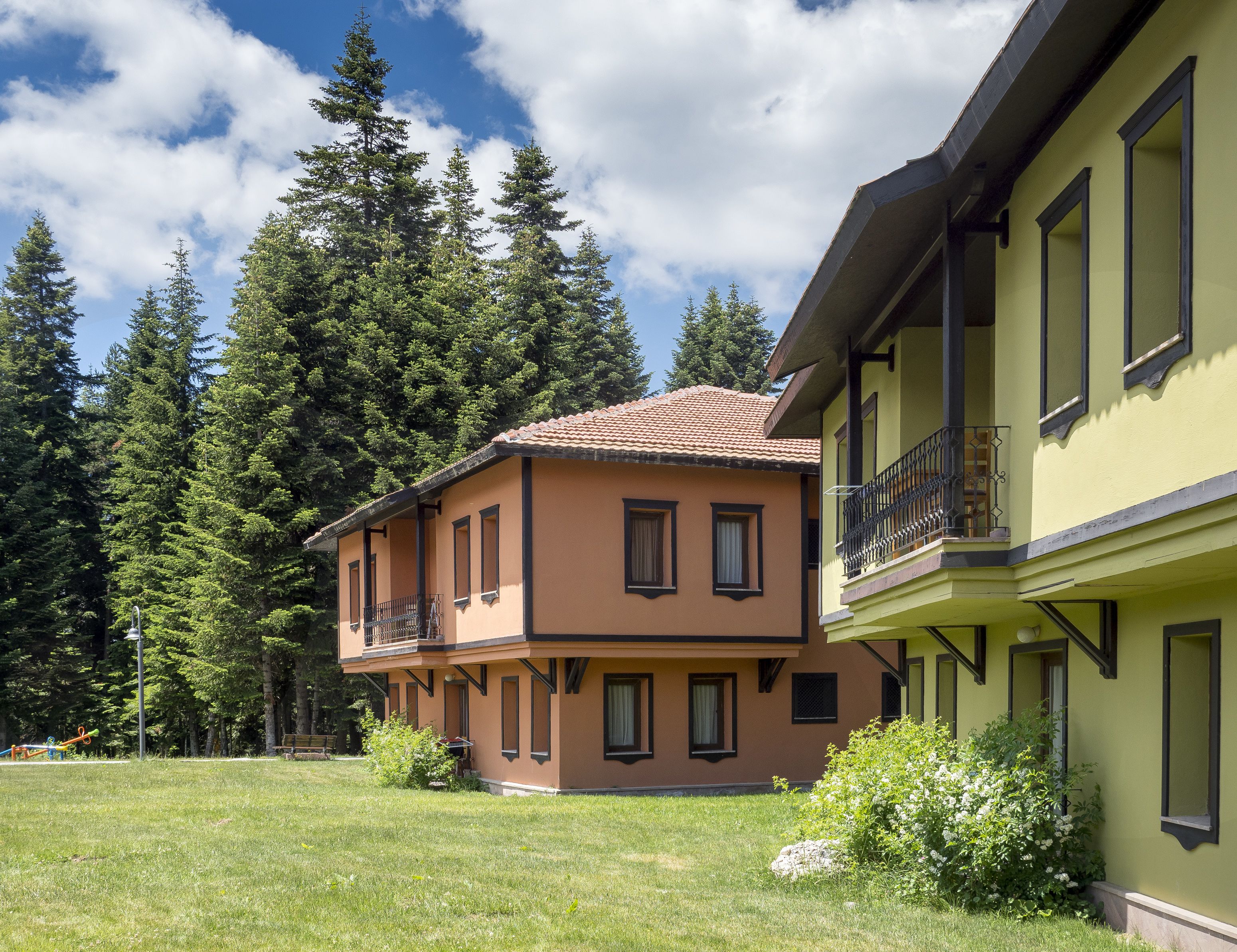 Ein zweistöckiges Gebäude mit Balkon und Garten.