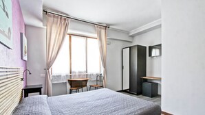 A modern hotel room with a large bed, a desk, and a wardrobe. - Vacanze a Roma (Rome)