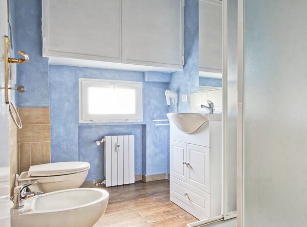 A bathroom with a toilet, sink, and window. - Vacanze a Roma (Rome)