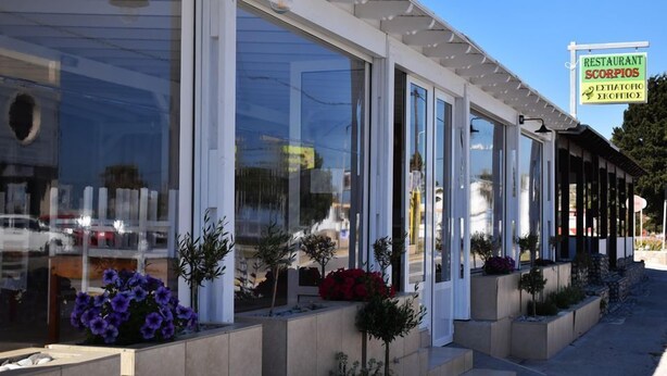 A restaurant with large windows and a signboard. - Villa Bel Passo (Kos)