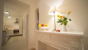 A bathroom with a vanity, a mirror, a lamp, and a vase with flowers. - Lovely Flats Englische Straße (Berlin)