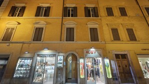 A multi-story building with storefronts, including a shoe store named "Patrizia" and a clothing store named "Ruby". - Shali Luxury Suite (Rome)