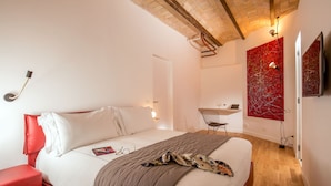 Un dormitorio moderno con una cama grande, una pared de acento roja y una silla roja.