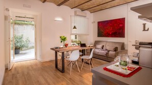 Una cocina moderna con una mesa de madera, sillas blancas y una bandeja roja decorativa.