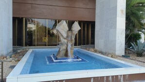 Un edificio moderno con piscina y una fuente central.