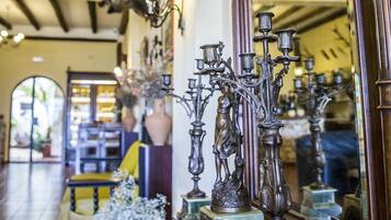 A room with a wooden ceiling, a mirror reflecting the room, and a table with decorative items.