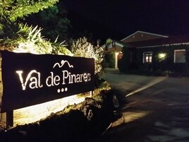 Señal que indica 'Val de Pinarees', con un sendero que lleva a un edificio.