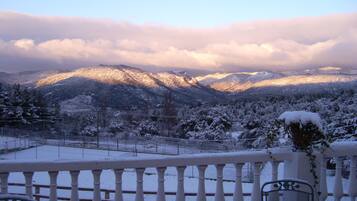 Un balcó amb vista a muntanyes cobertes de neu i una tanca.