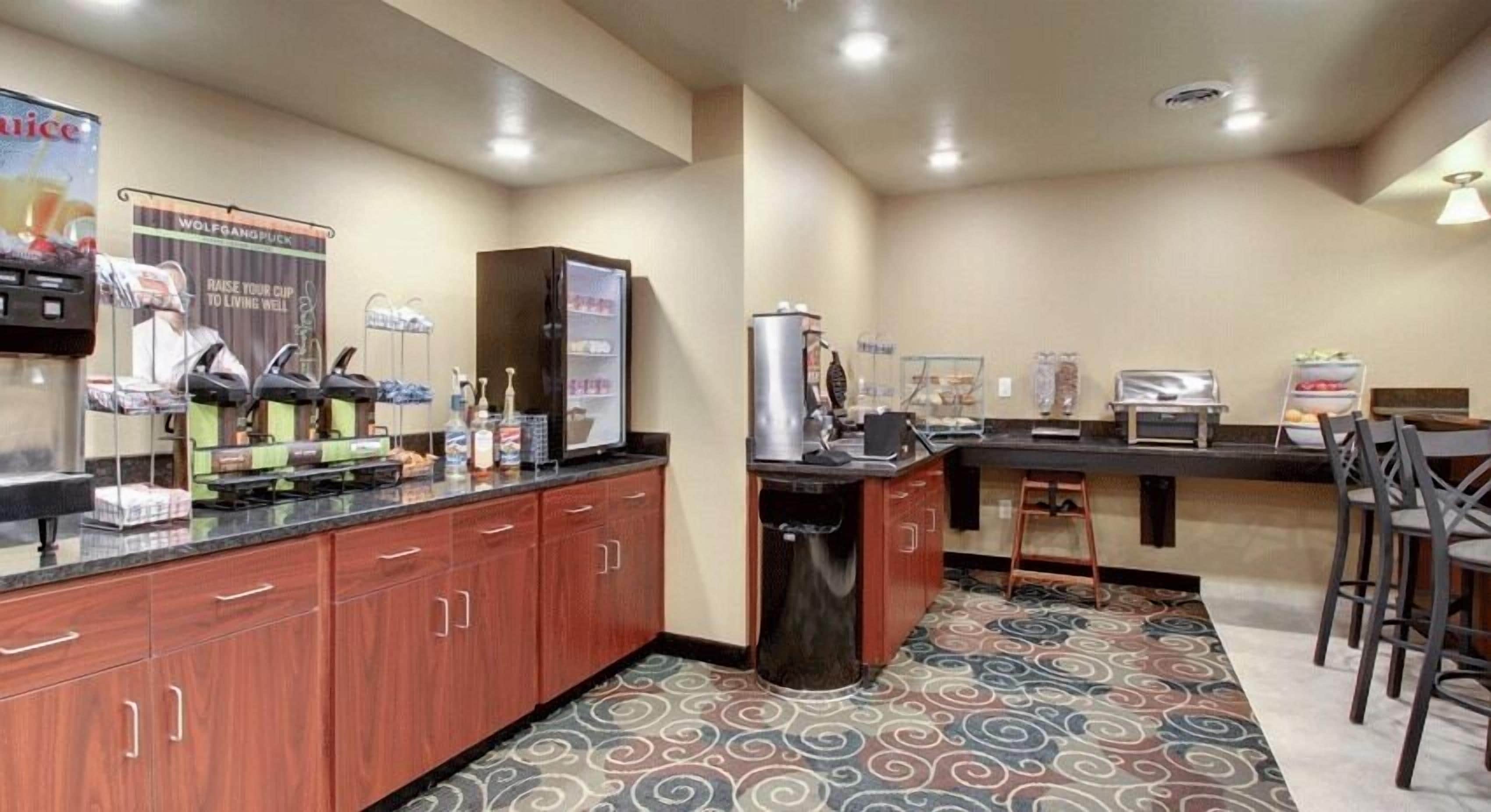 Une cuisine d’hôtel équipée d’un coin café, d’un réfrigérateur et d’un four à micro-ondes.