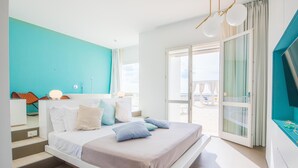 Een moderne slaapkamer met een bed, een badkamer en uitzicht op het omliggende landschap.
