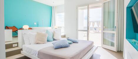 Un dormitorio moderno con cama, baño y vistas al exterior.