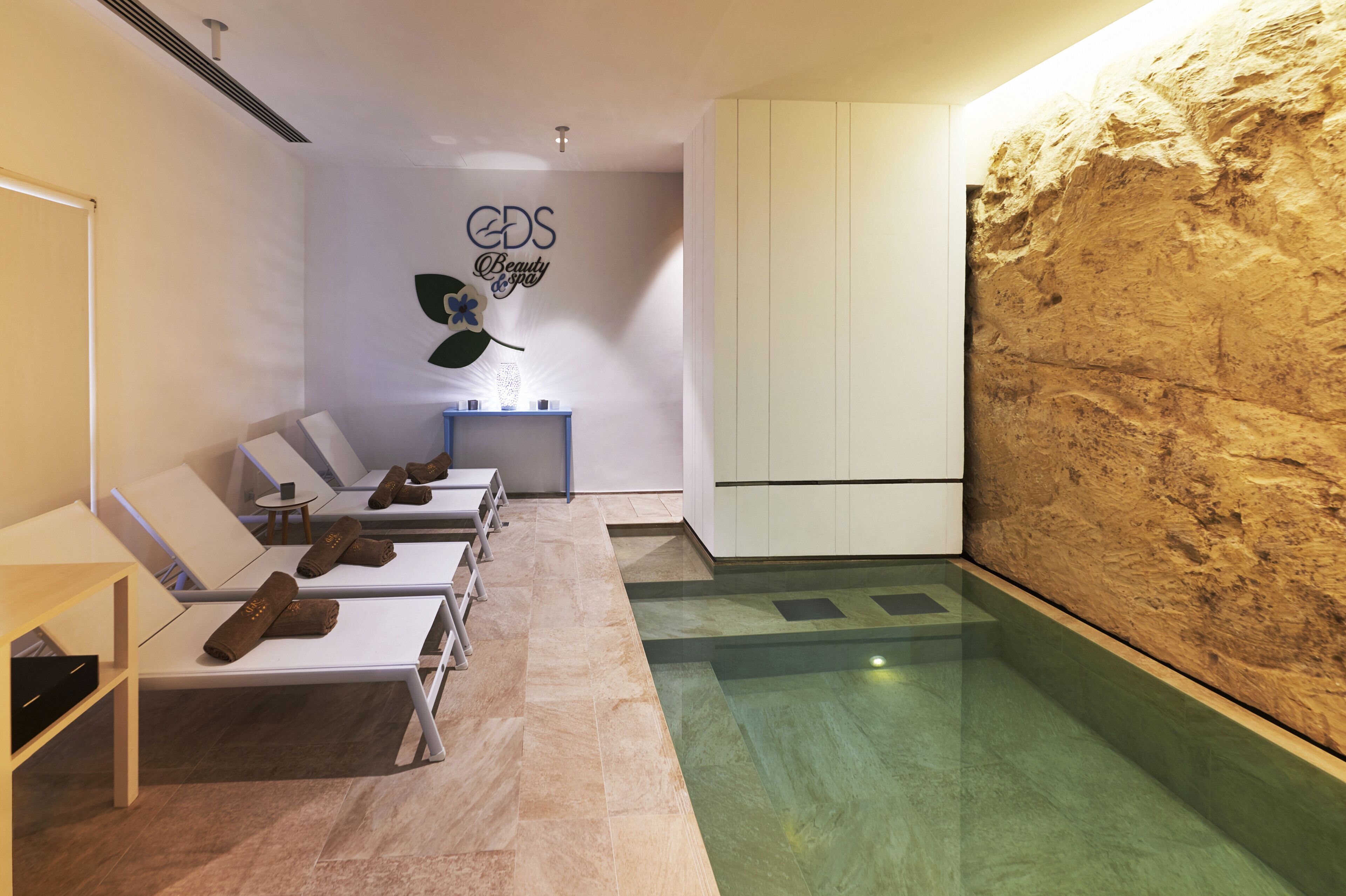 Un cuarto de spa con un amplio mural en la pared, un mostrador de recepción y una zona de piscina.