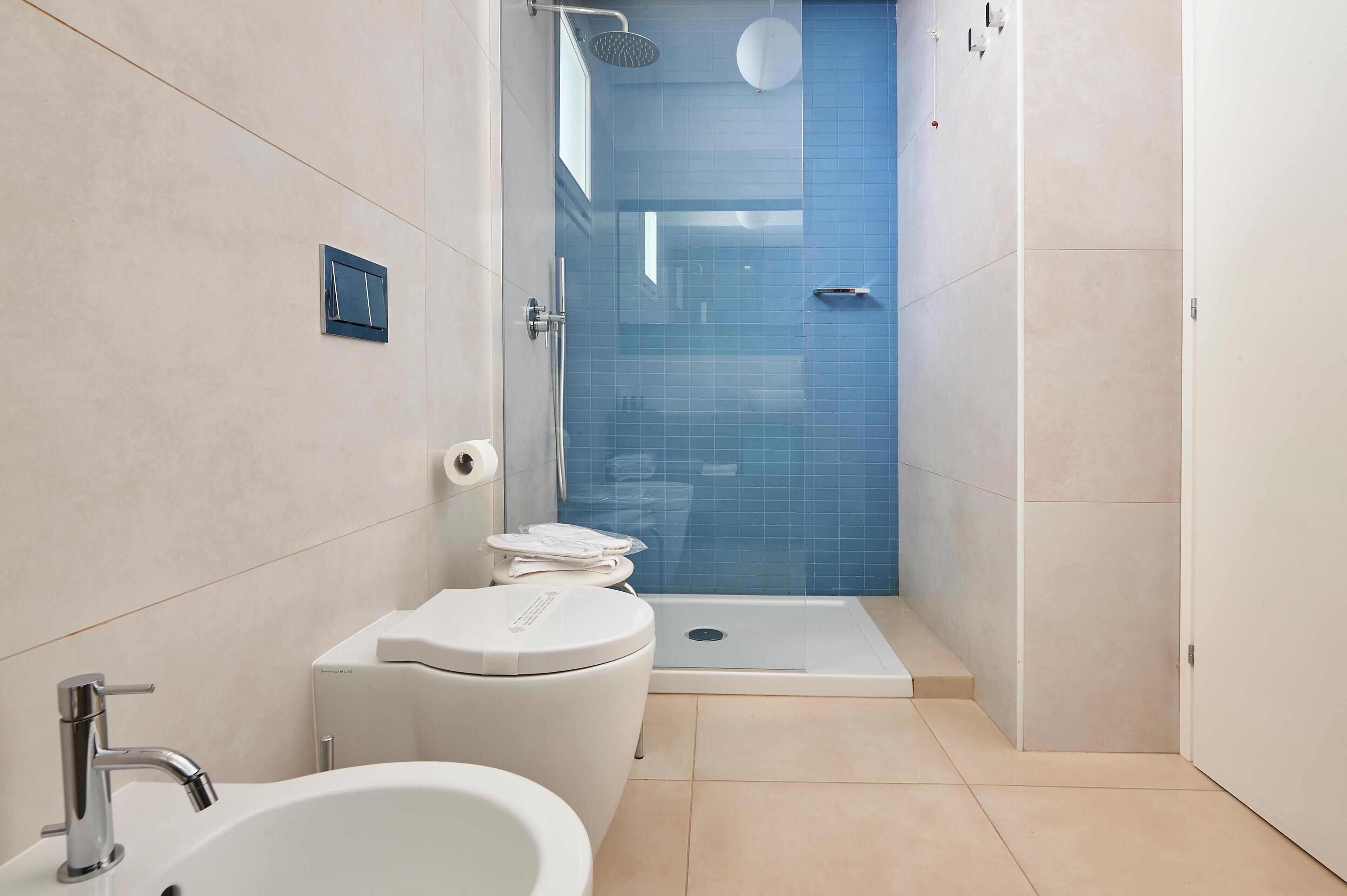 A modern bathroom with a toilet, sink, and shower area.