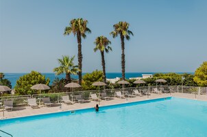 Una piscina al aire libre de temporada, sombrillas