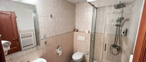 A bathroom with a sink, toilet, and glass-enclosed shower.