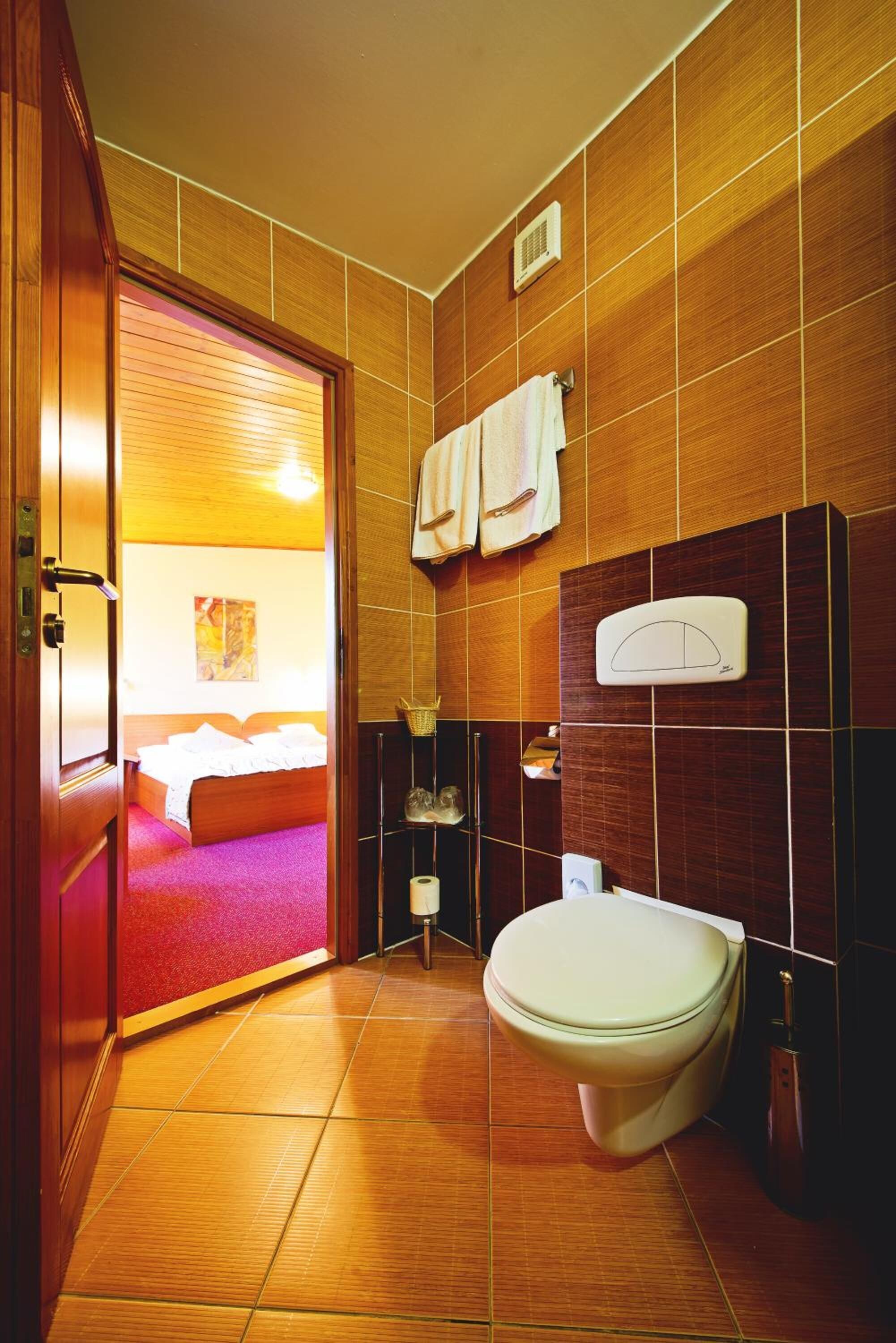 A modern bathroom with a toilet, towel rack, and a shower area.