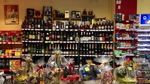 A liquor store with shelves of alcohol bottles and gift baskets. - Tavel Boutique Hotel (Prešov)