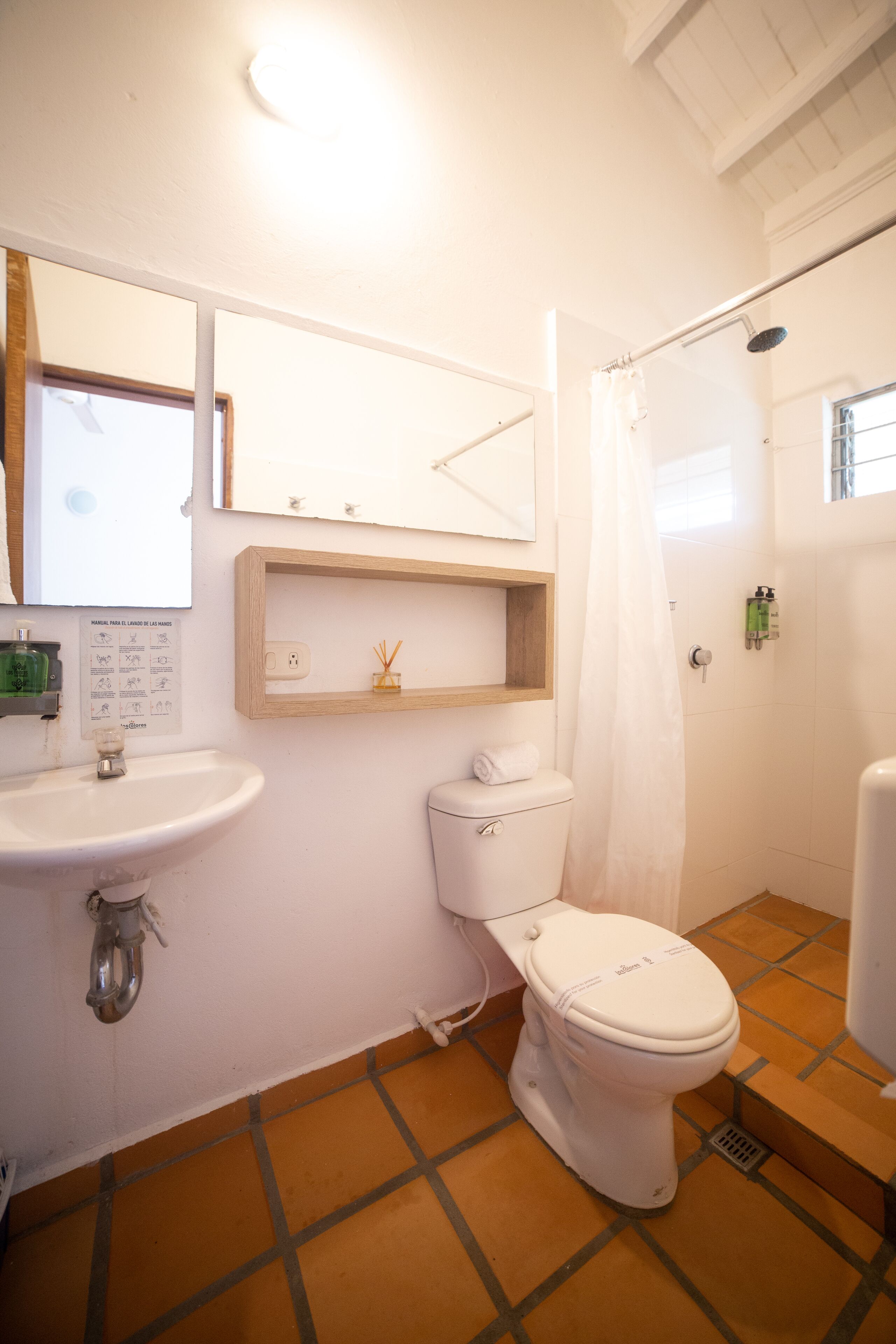 Een badkamer met toilet, wastafel en douchegordijn.