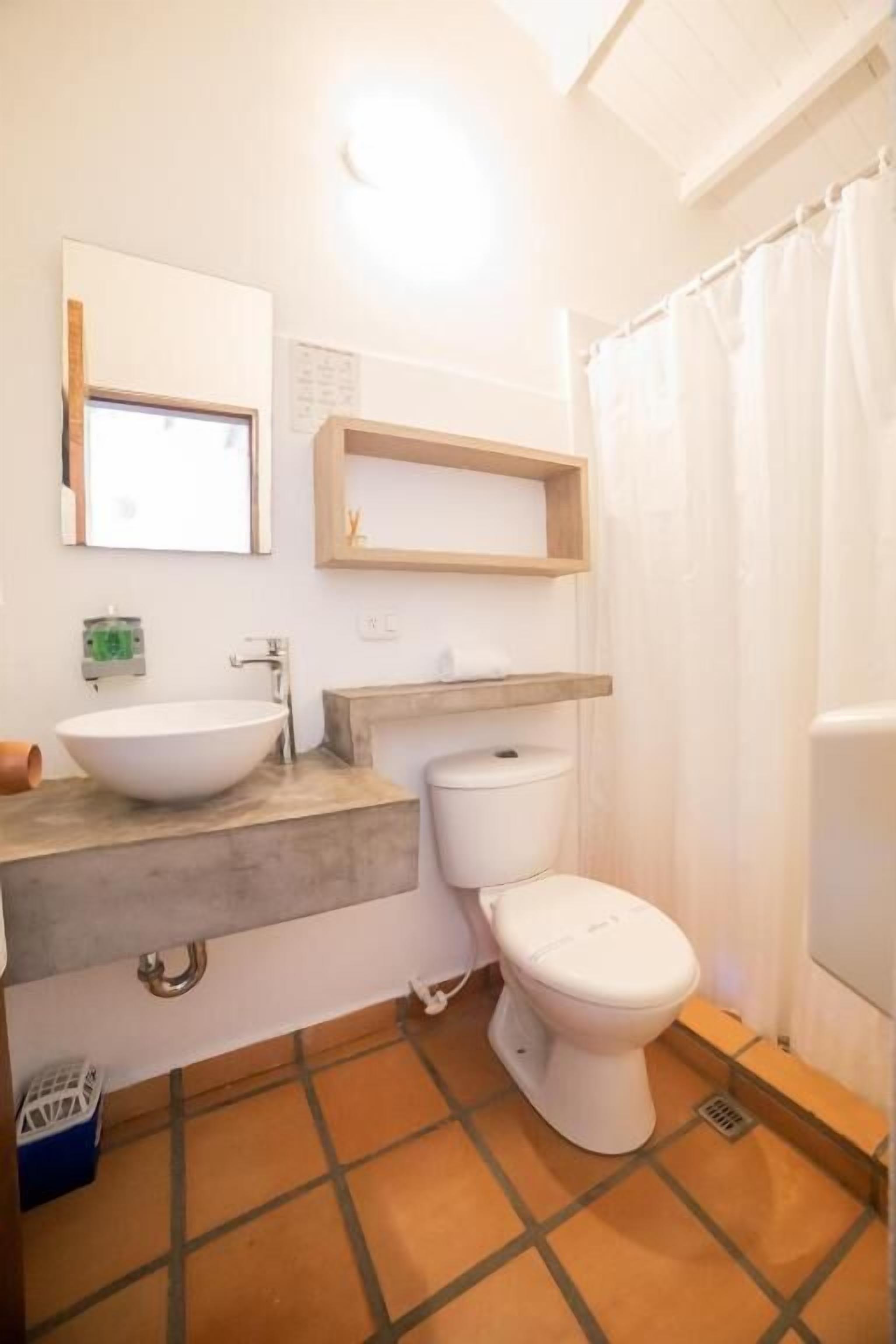 Ein Badezimmer mit einem weißen Waschbecken, einer Toilette und einer Duschvorhang.