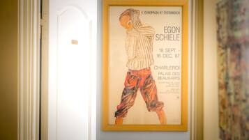A framed artwork on a wall in a hallway.