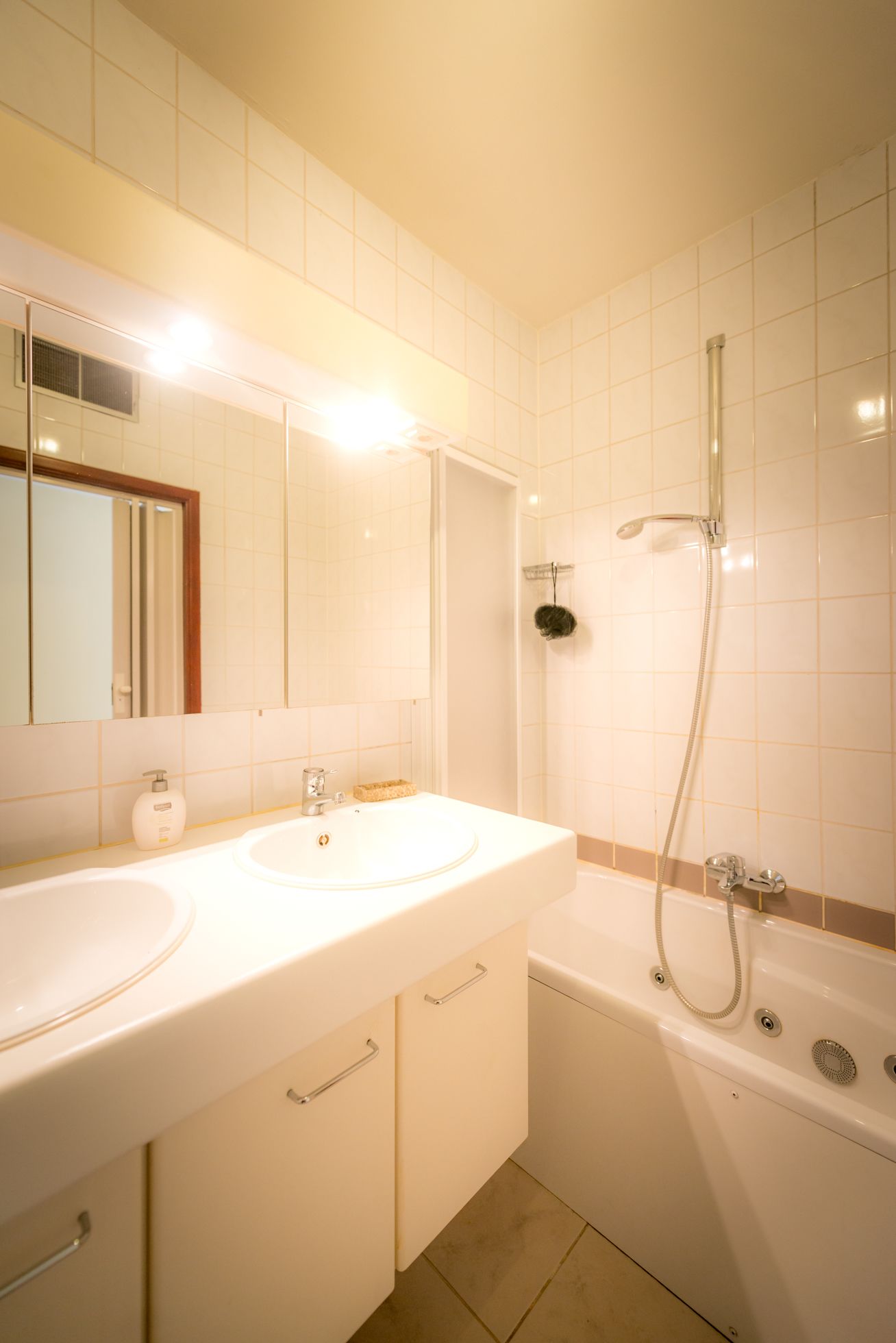 Un baño con dos lavamanos, un espejo, ducha y bañera.