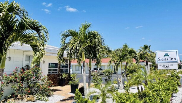 Un hotel con un cartel que indica tarifas diarias bajas, WiFi gratuito y una política de vacunación.