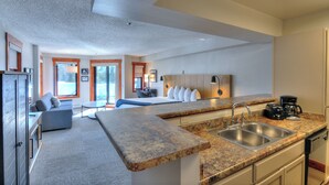 A modern kitchen with granite countertops, stainless steel sinks, and a coffee maker. - Wedgewood Lodge (Breckenridge)