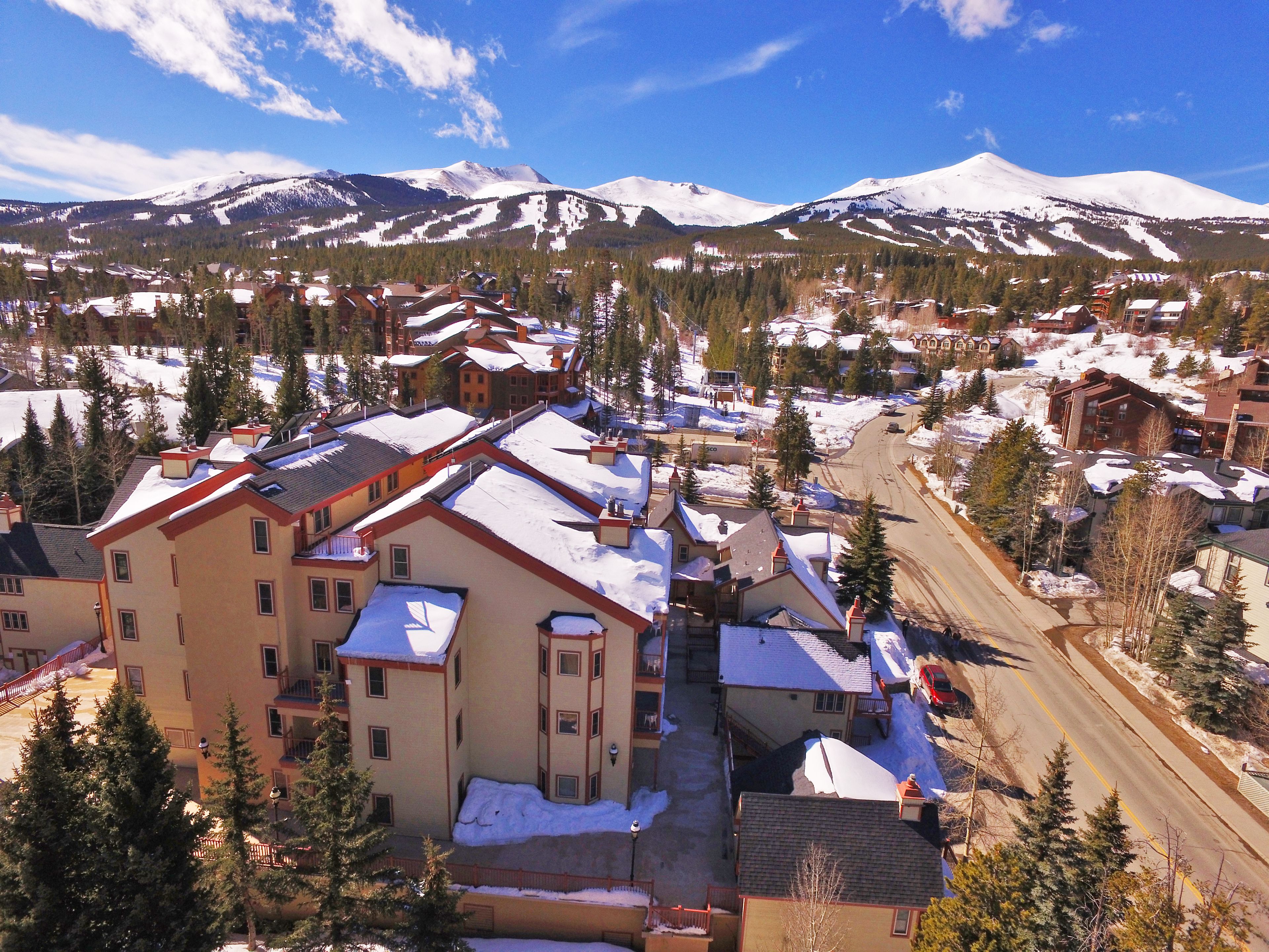 Un pueblo cubierto de nieve con edificios y una montaña al fondo.