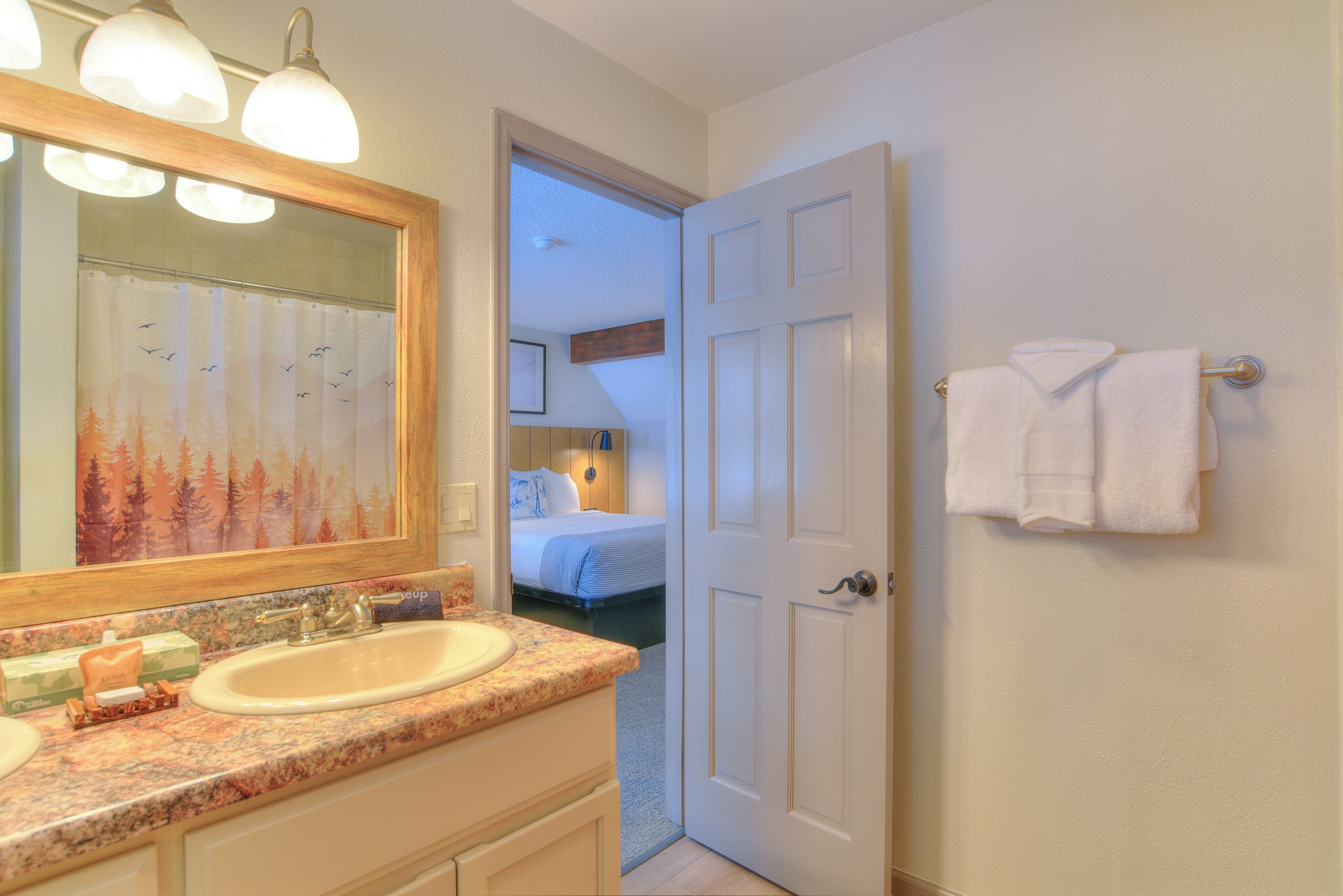 A bathroom with a sink, mirror, and towel rack.