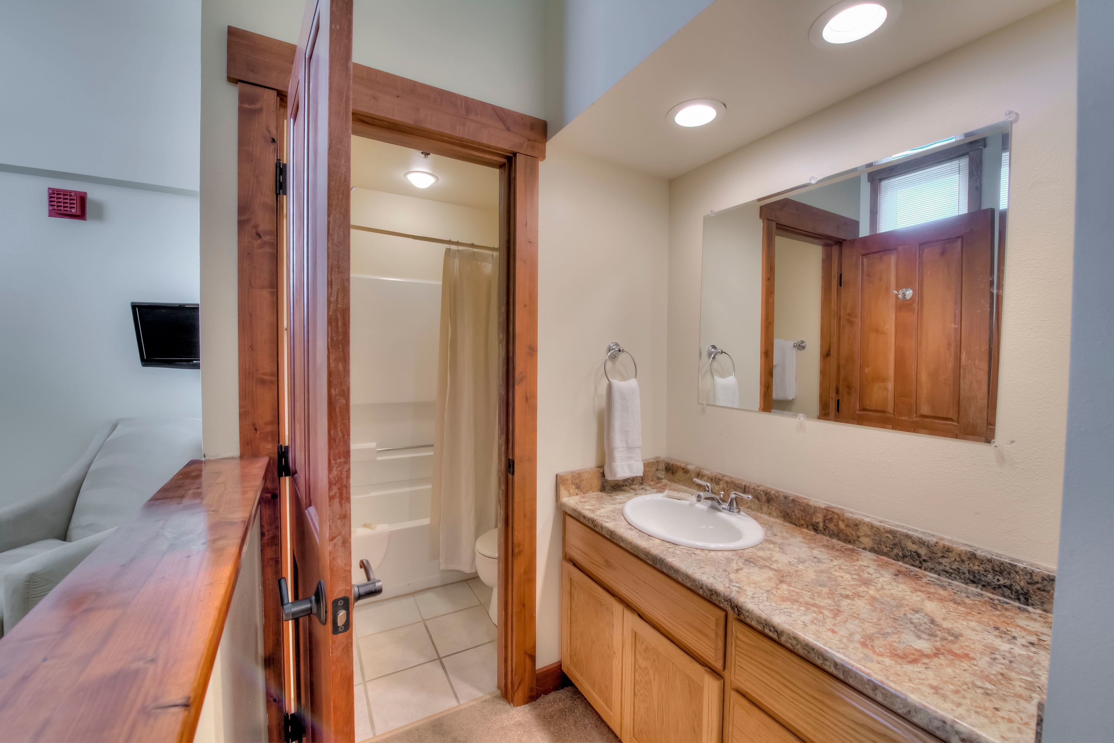 Une salle de bain avec un meuble-lavabo en bois, un évier et un miroir.