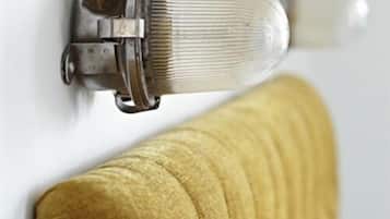 A close-up of a brass valve attached to a white wall, with a yellow textured object partially visible.