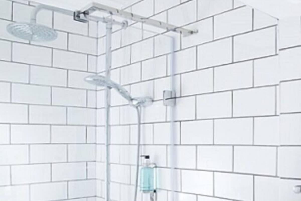 A shower with a handheld showerhead and a wall-mounted faucet.