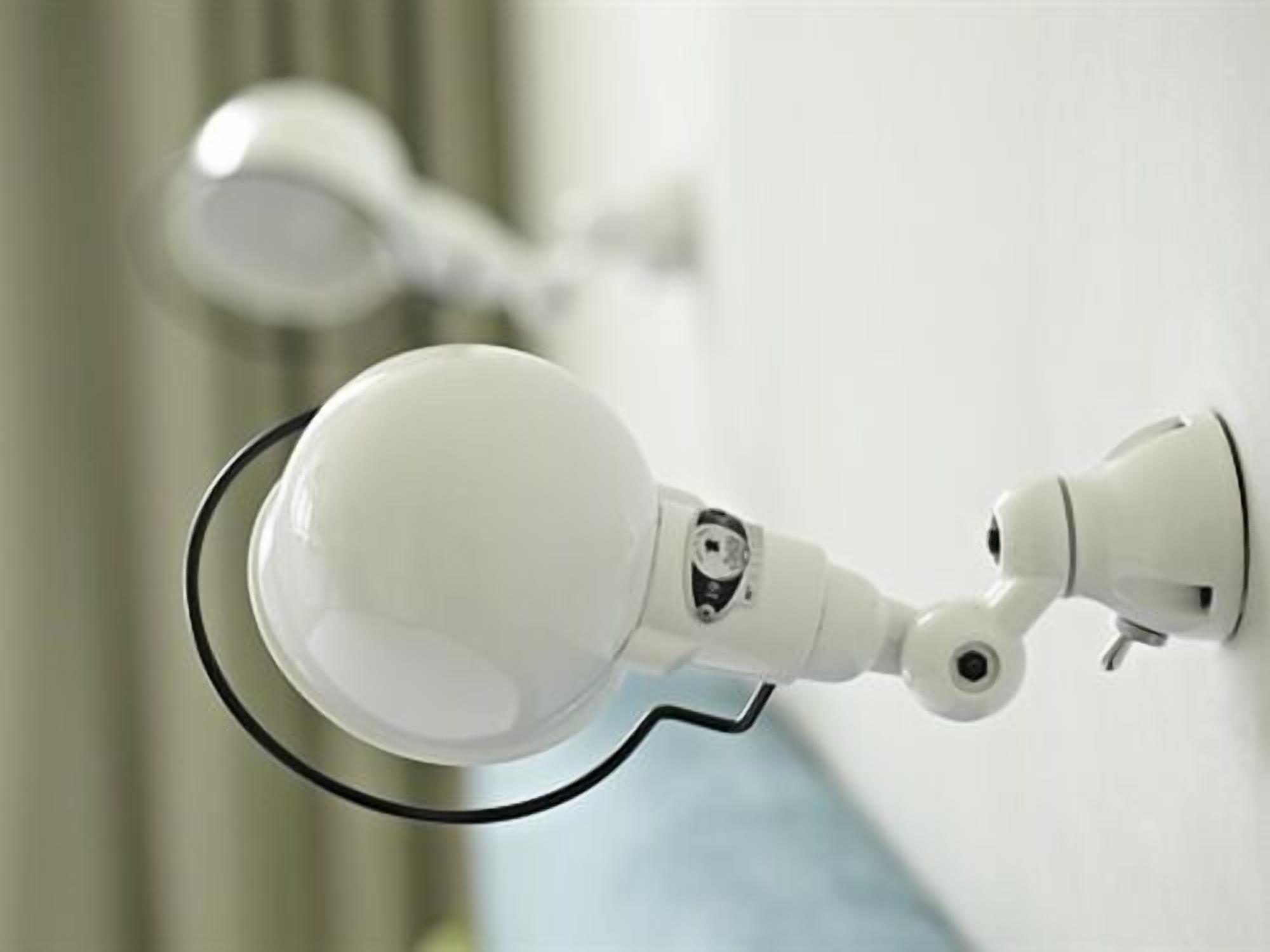 A white security camera mounted on a wall.