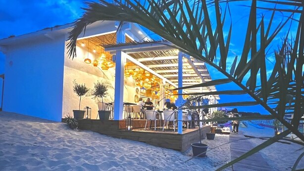 Un restaurant situé en bord de mer, avec une terrasse extérieure et une zone patio couverte.