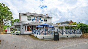 A two-story building with a sign reading "The Running Horse Inn" and a blue fence surrounding the entrance. - The Running Horse (Winchester)