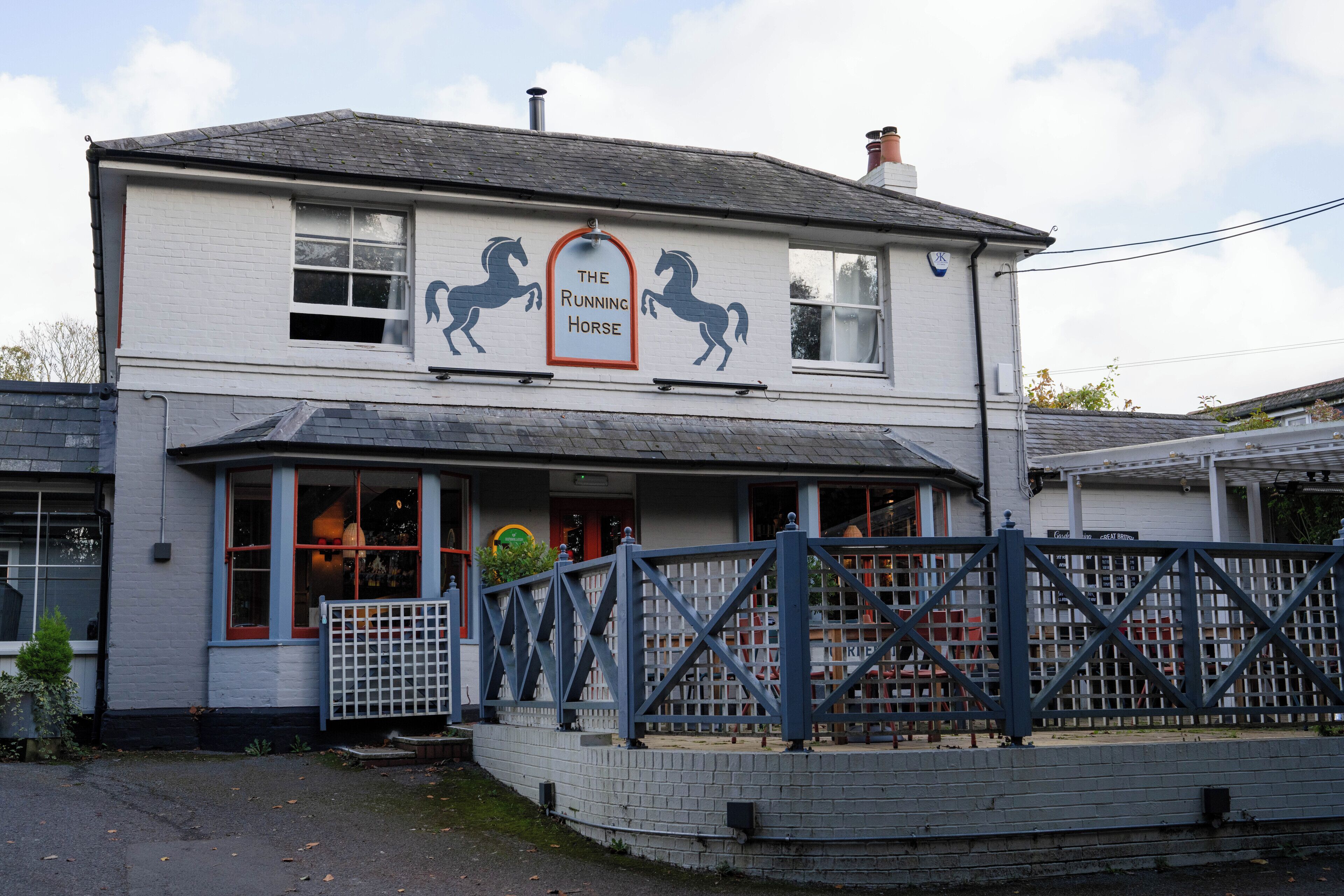 A two-story building with a sign reading "The Running Horse."