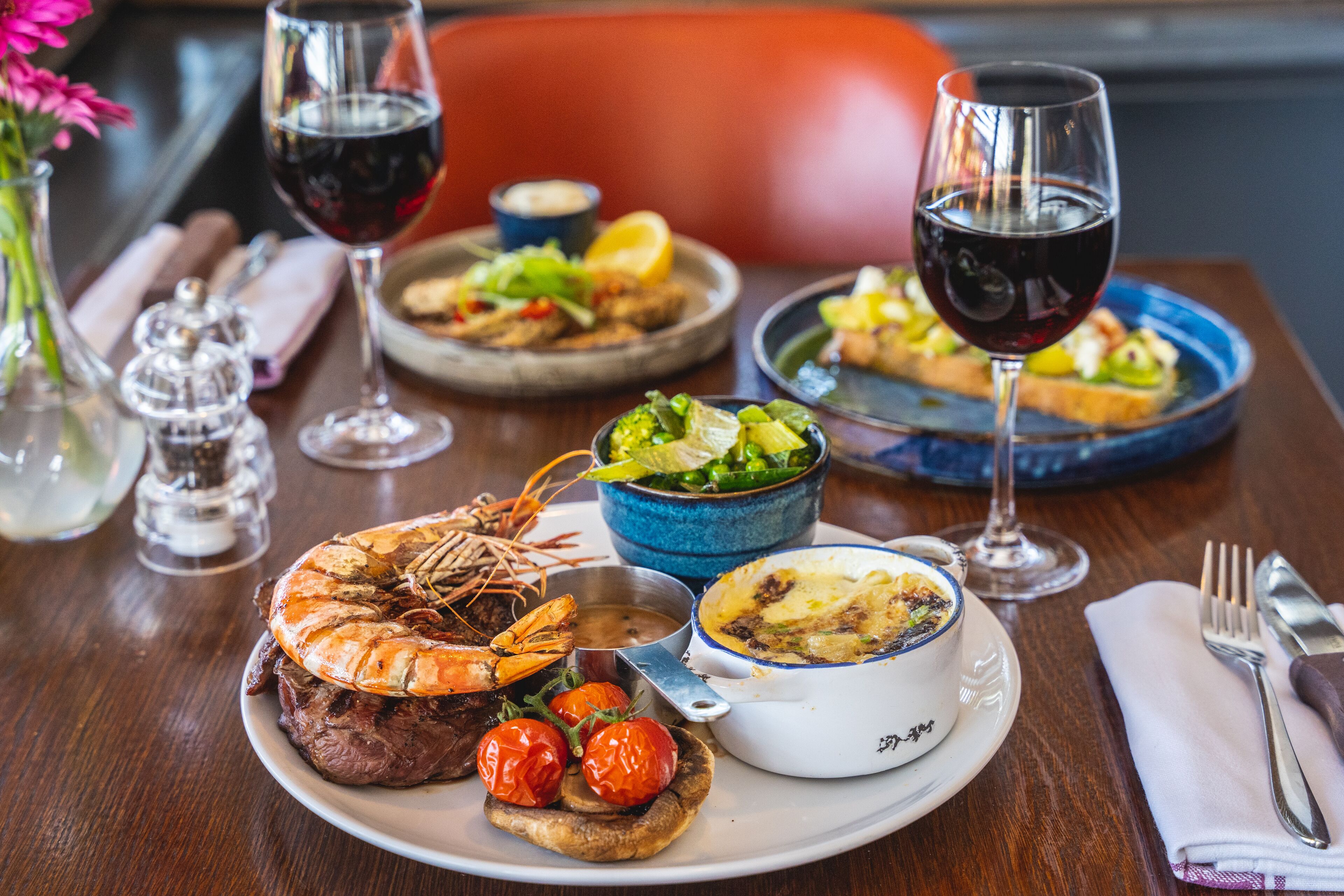 A dining table with various dishes, including seafood, salad, and a bowl of soup.