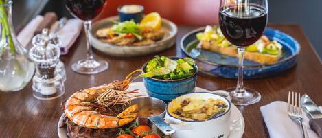 A dining table with various dishes, including seafood, salad, and a bowl of soup.