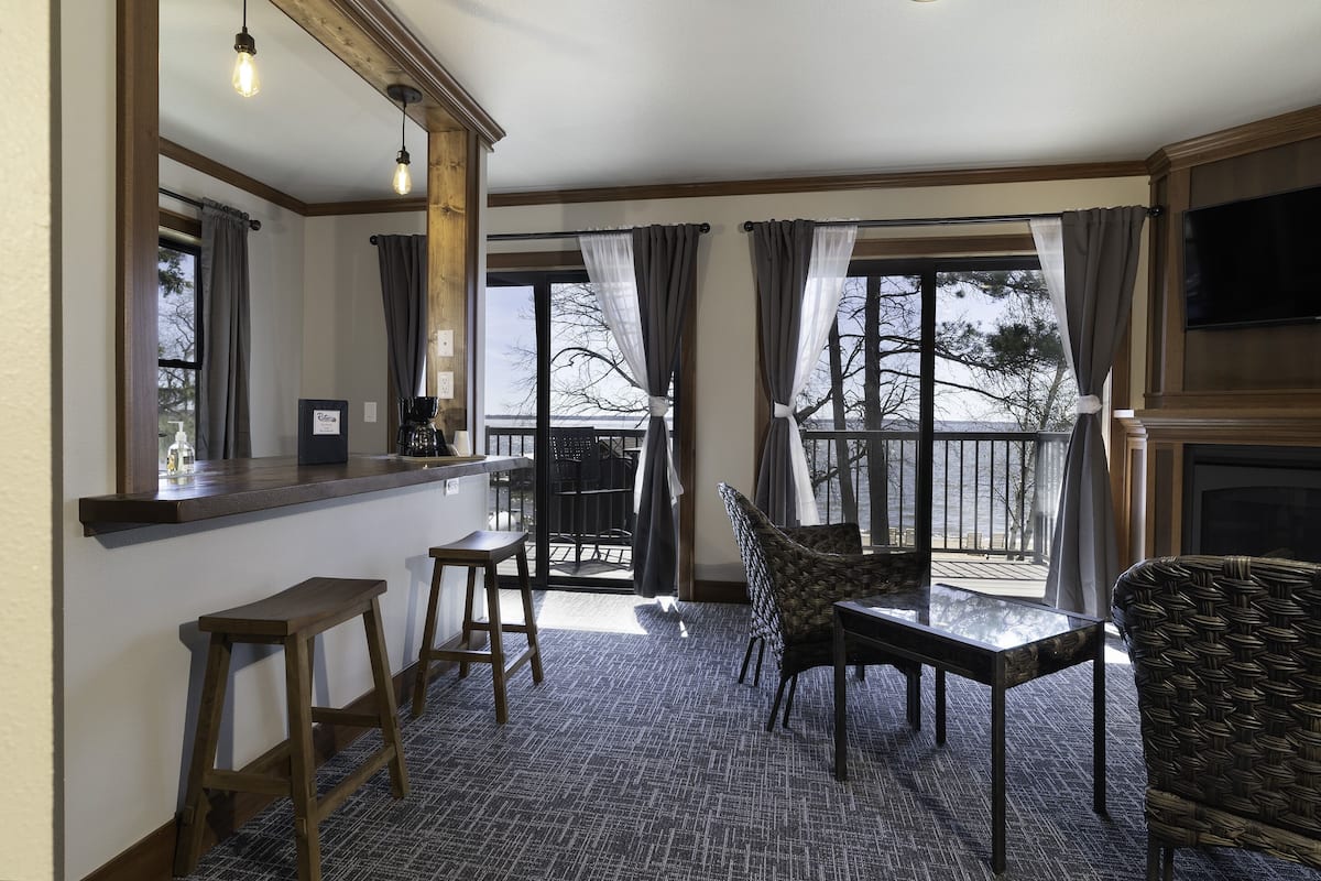 Een knus verblijf met een barhoek, een grote spiegel en uitzicht op het balkon.