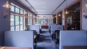 A modern restaurant with high ceilings, pendant lighting, and large windows. - Ruttger's Birchmont Lodge (Bemidji)