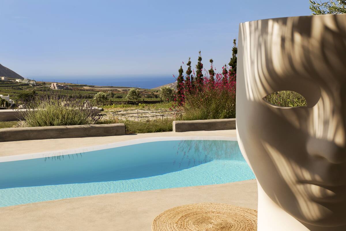 A pool with a clear view of the ocean and hills in the background.