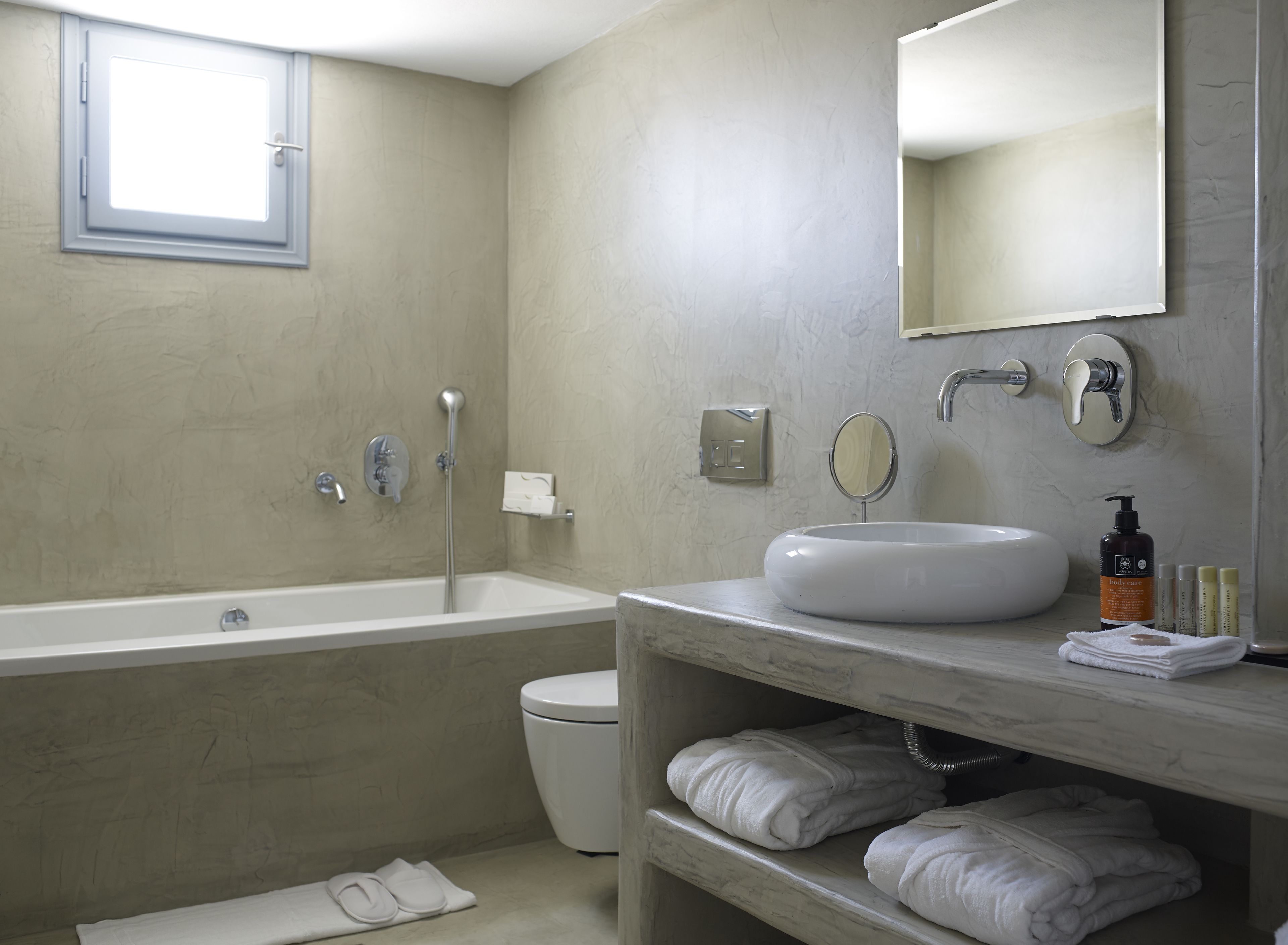 Une salle de bain moderne avec une baignoire, des toilettes et un meuble-lavabo.