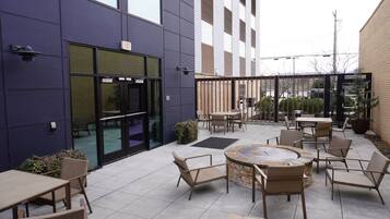 Un área de patio exterior con asientos y un hogar para fuego.
