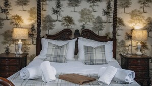 A bedroom with a large bed, two bedside tables, and a canopy bedspread. - The George Inn (Warminster)