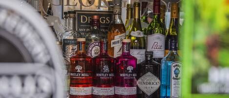 A variety of alcohol bottles on a shelf, including gin and wine.